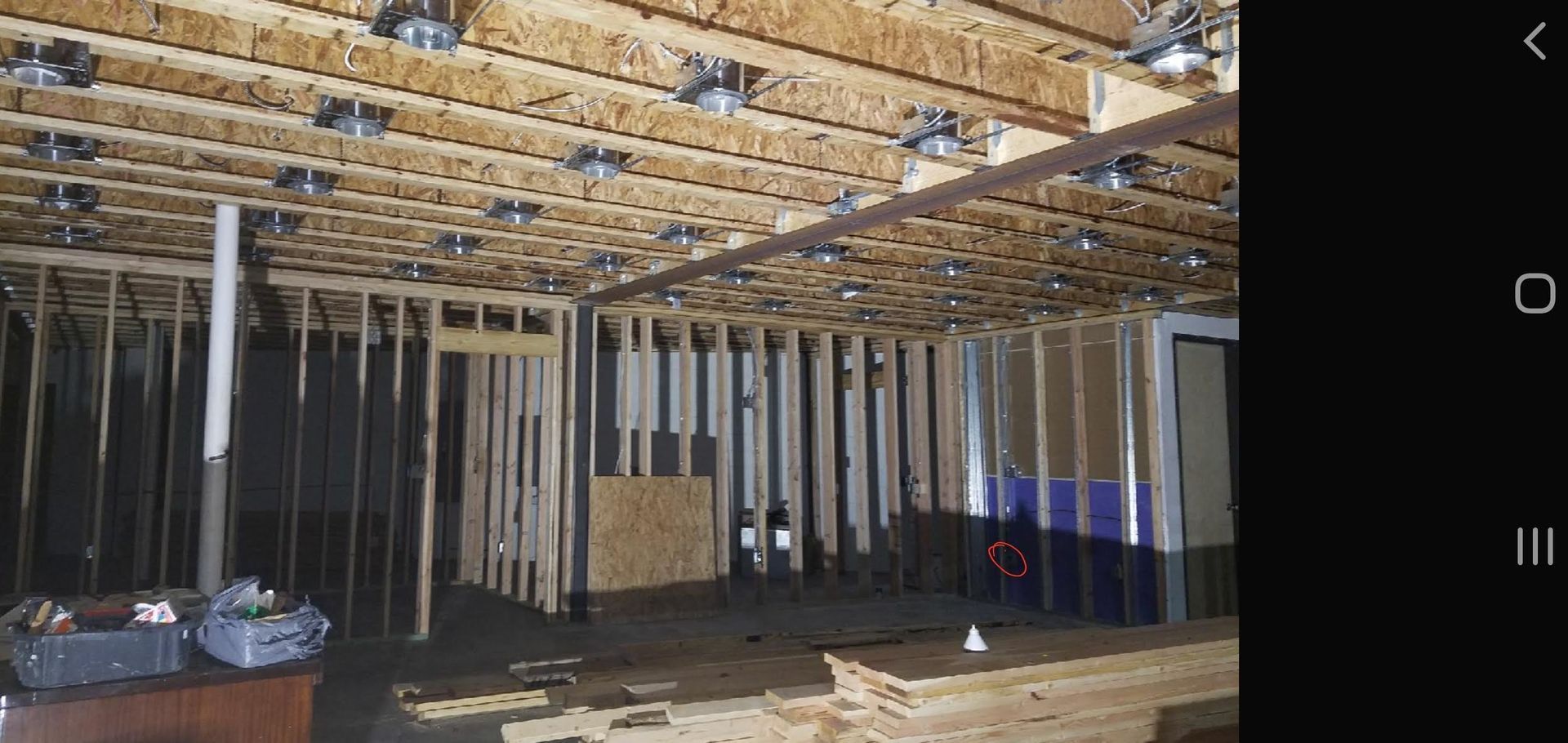 A picture of a basement under construction on a cell phone.