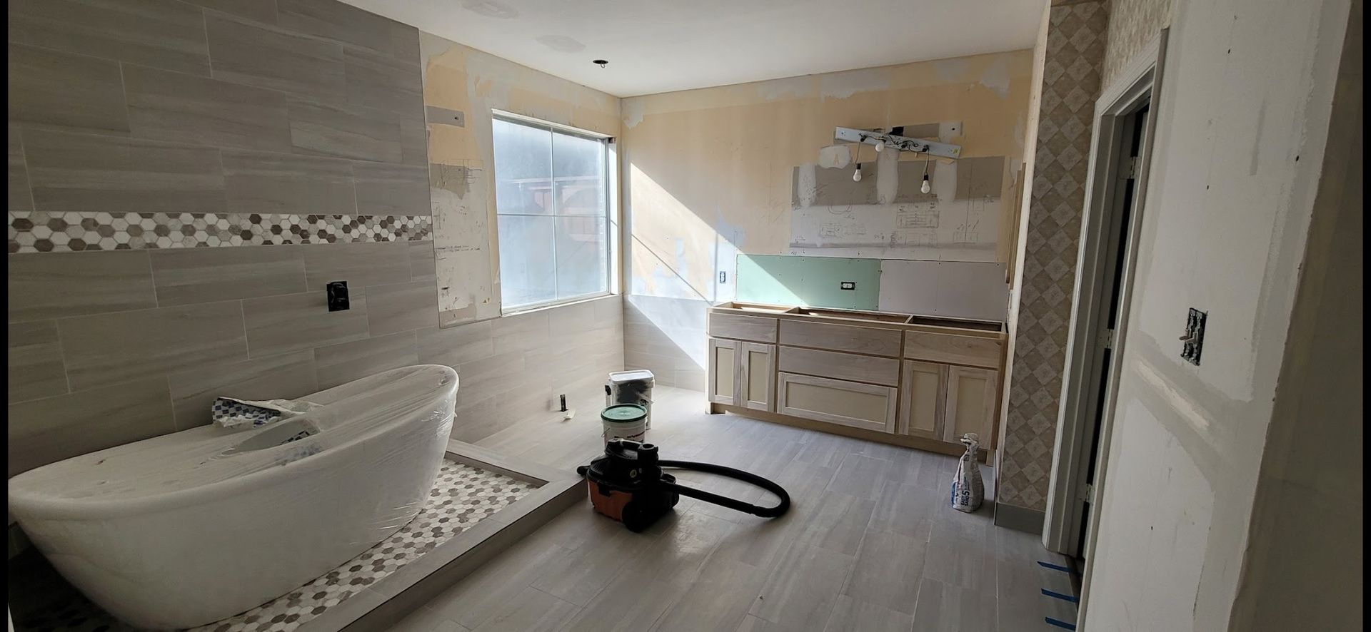 A bathroom with a tub and a vacuum cleaner in it.