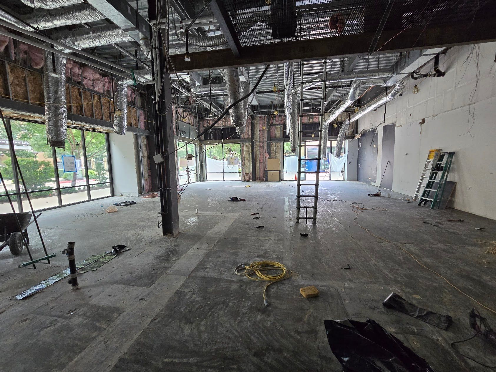 A large empty room with a ladder in the middle of it.