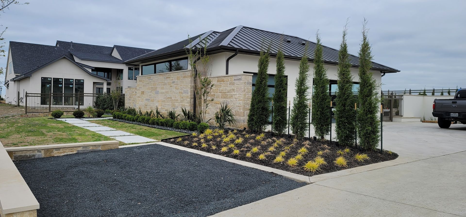 A large white house with a black roof and a truck parked in front of it.