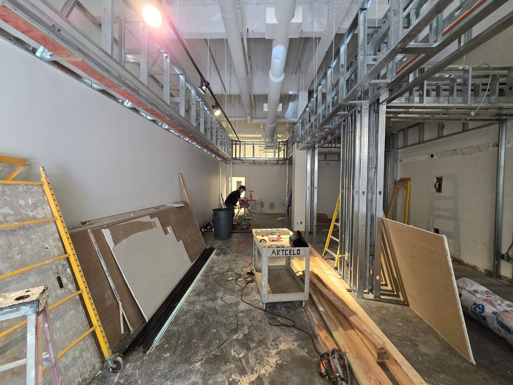A man is standing in the middle of a building under construction.