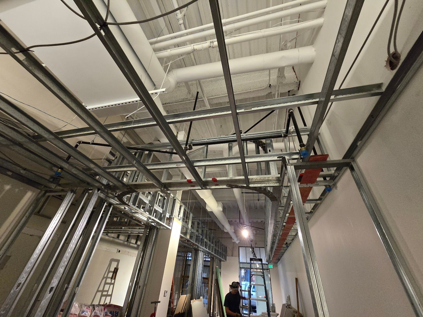 A building under construction with a lot of wires hanging from the ceiling.