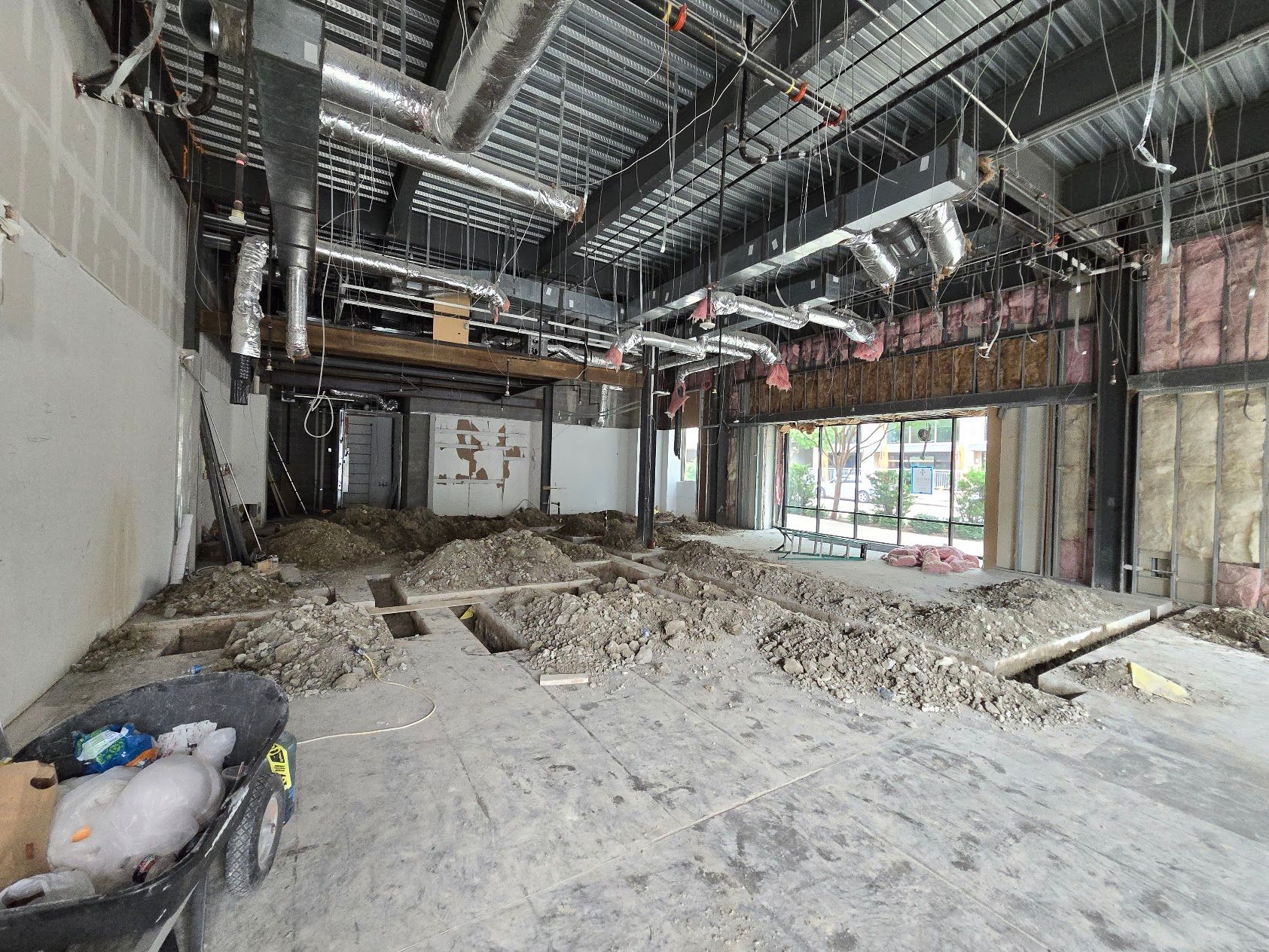 A large empty room with a wheelbarrow in the middle of it.