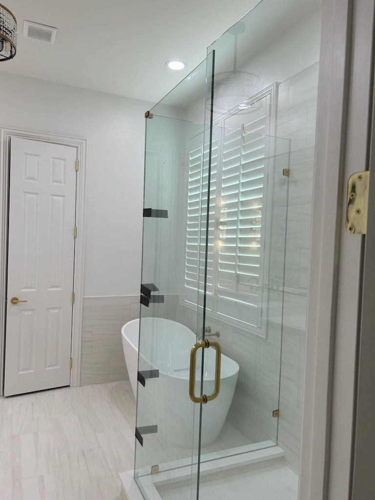 A bathroom with a tub and a shower with a glass door.