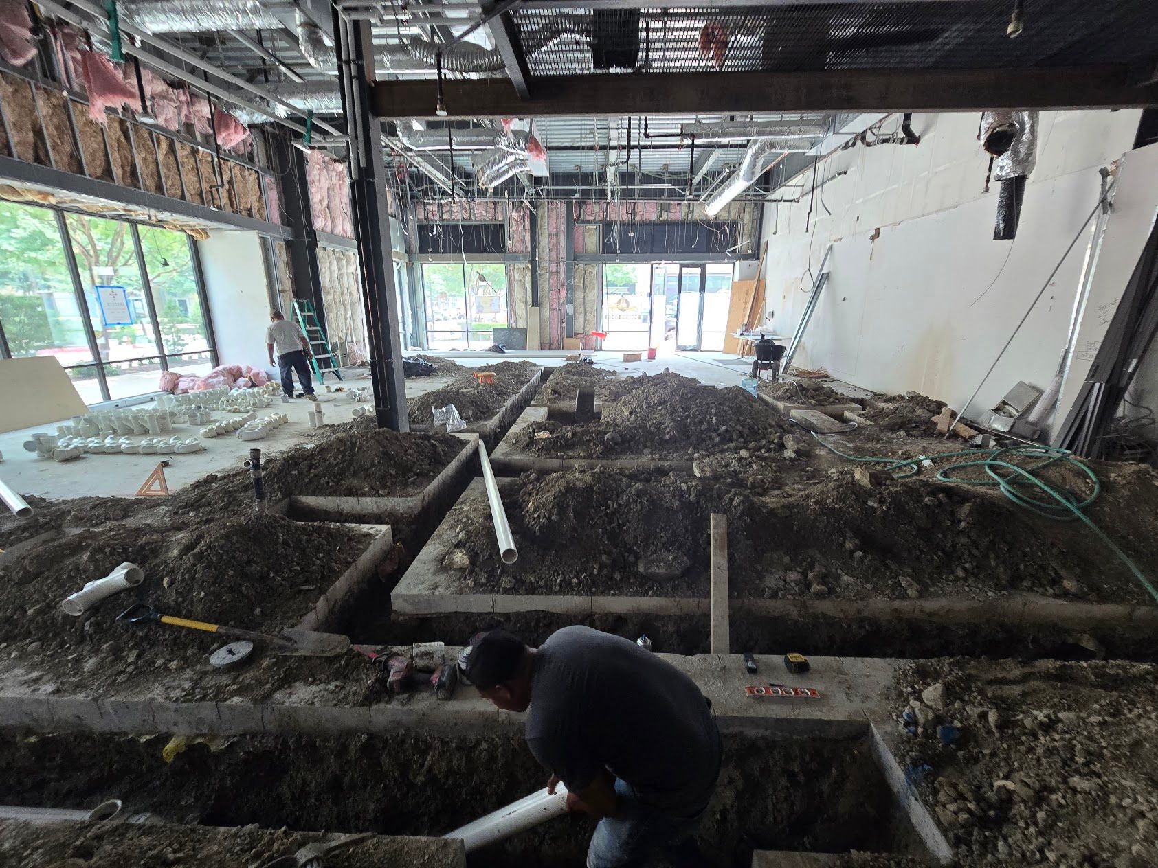 A man is digging in the dirt in a building under construction.