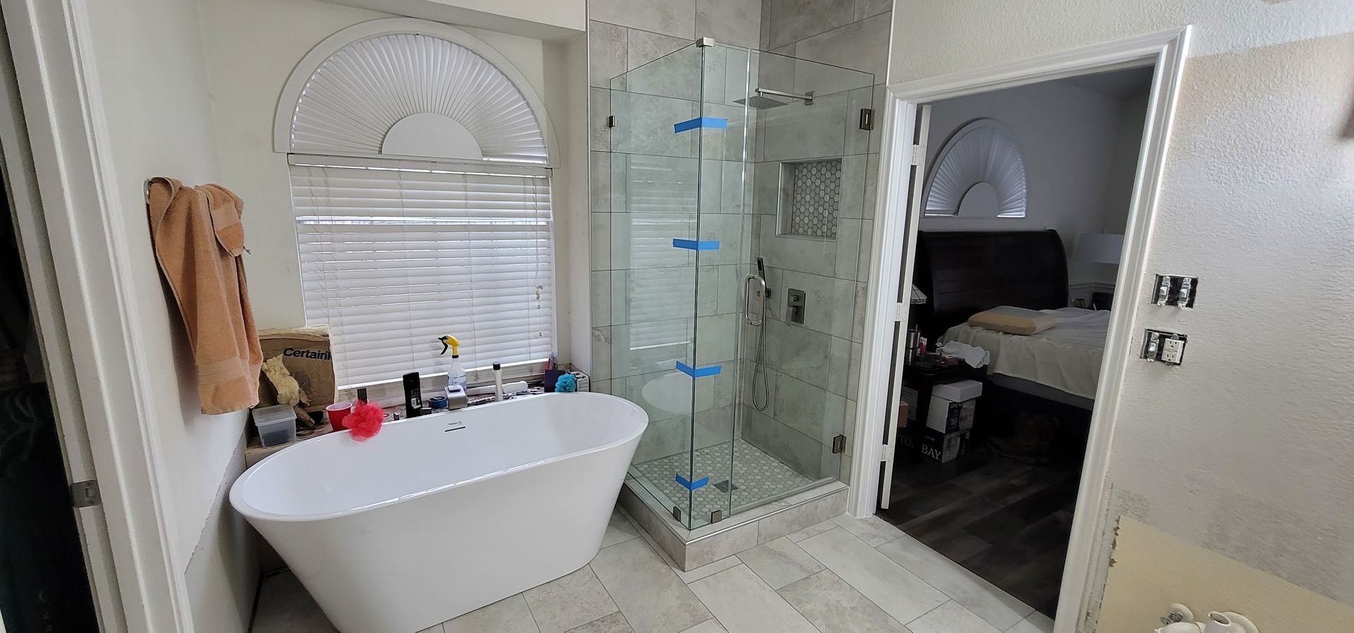 A bathroom with a tub , shower , and mirror.
