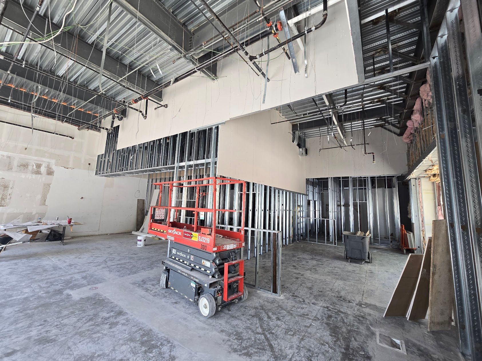 A construction site with a scissor lift in the middle of it.