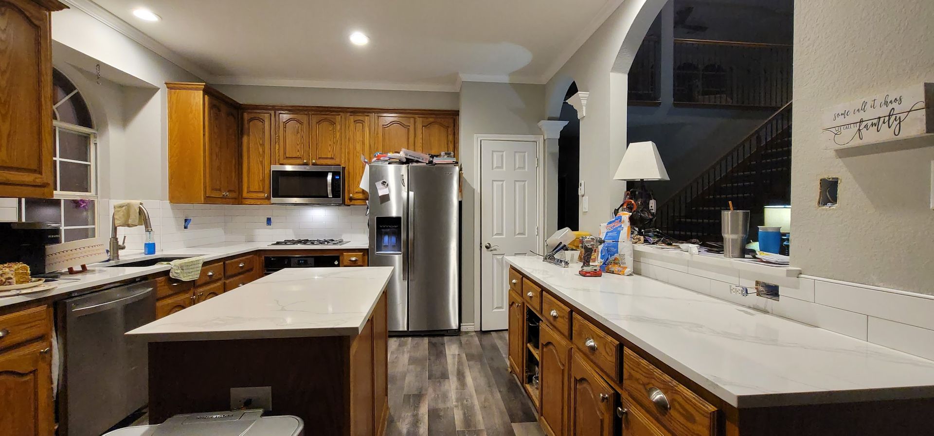 A kitchen with wooden cabinets , stainless steel appliances , and a large island.