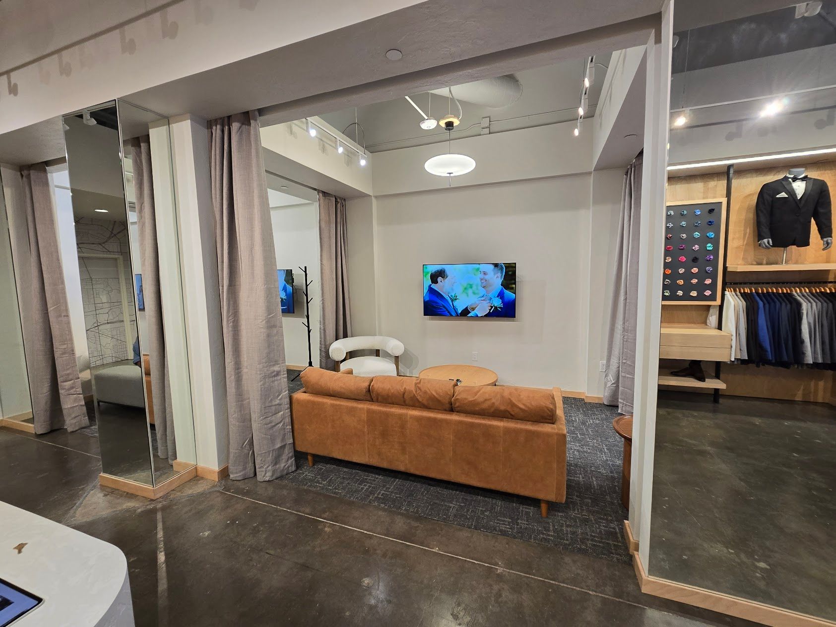 A living room with a couch and a flat screen tv on the wall.
