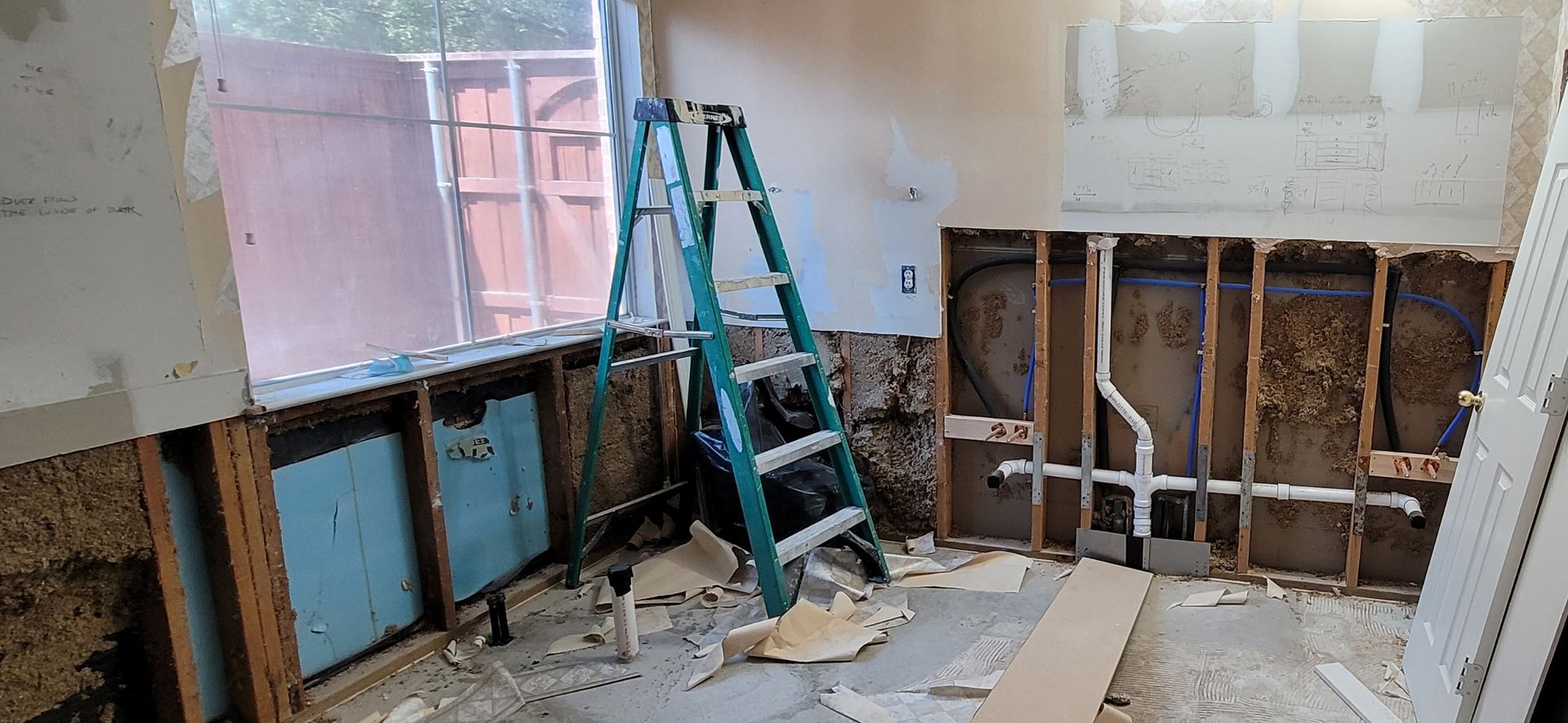 A ladder is sitting in the middle of a room that is being remodeled.