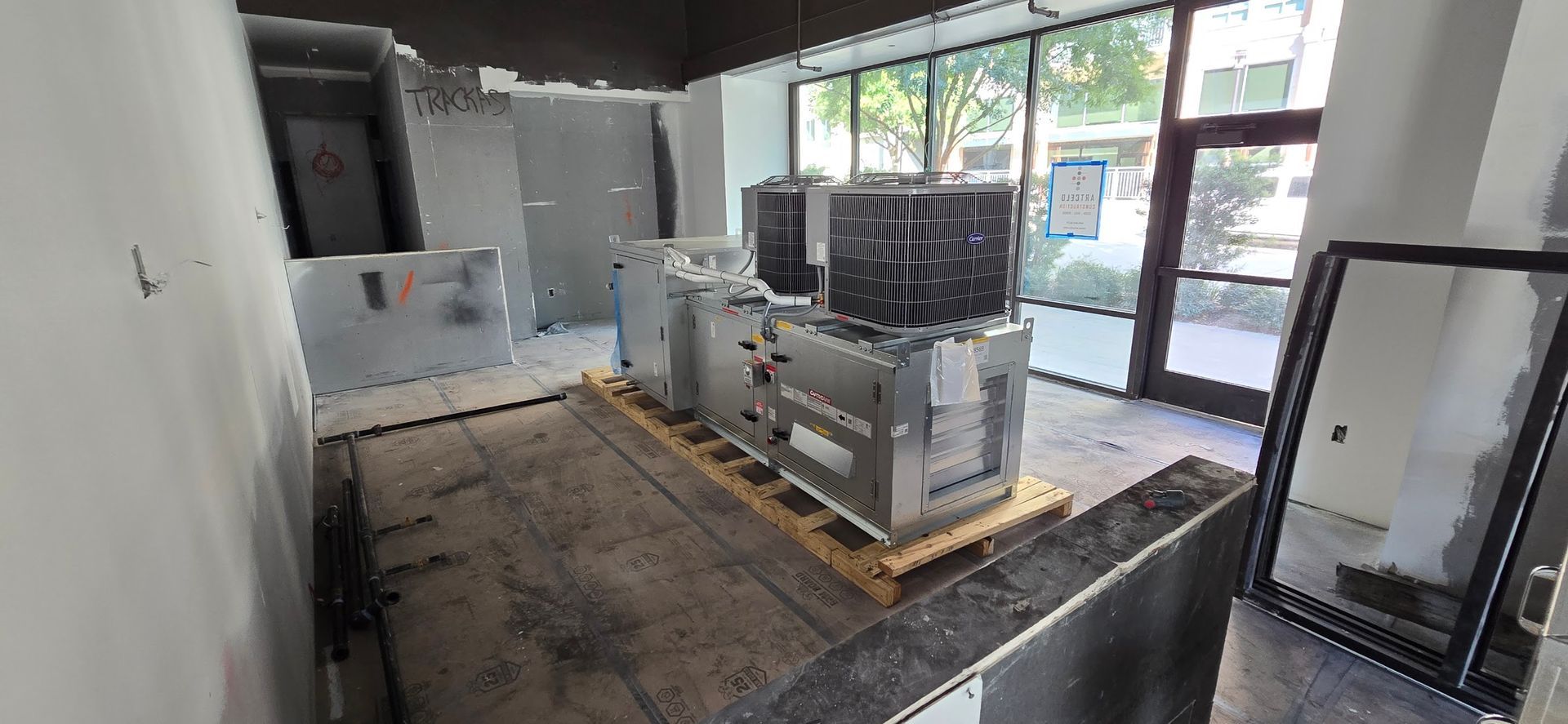 A large machine is sitting on top of a wooden pallet in a room.