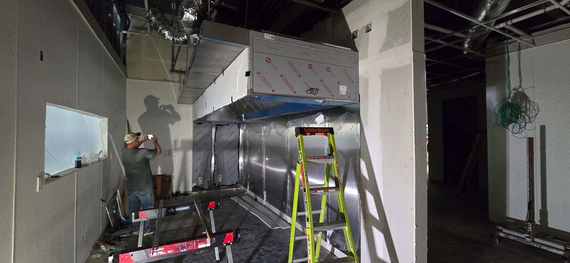 A man is standing on a ladder in a room.