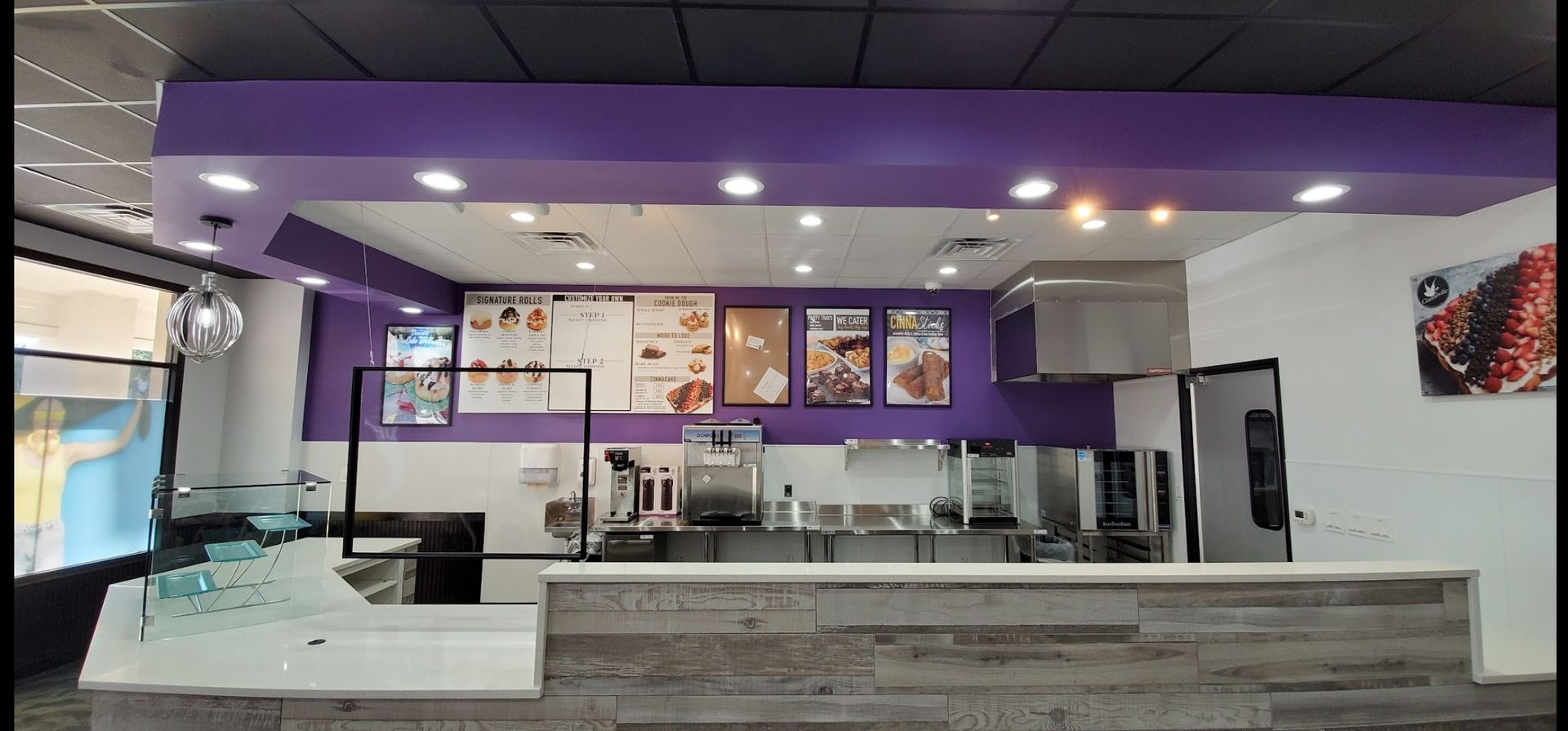 The inside of a restaurant with purple walls and a counter.