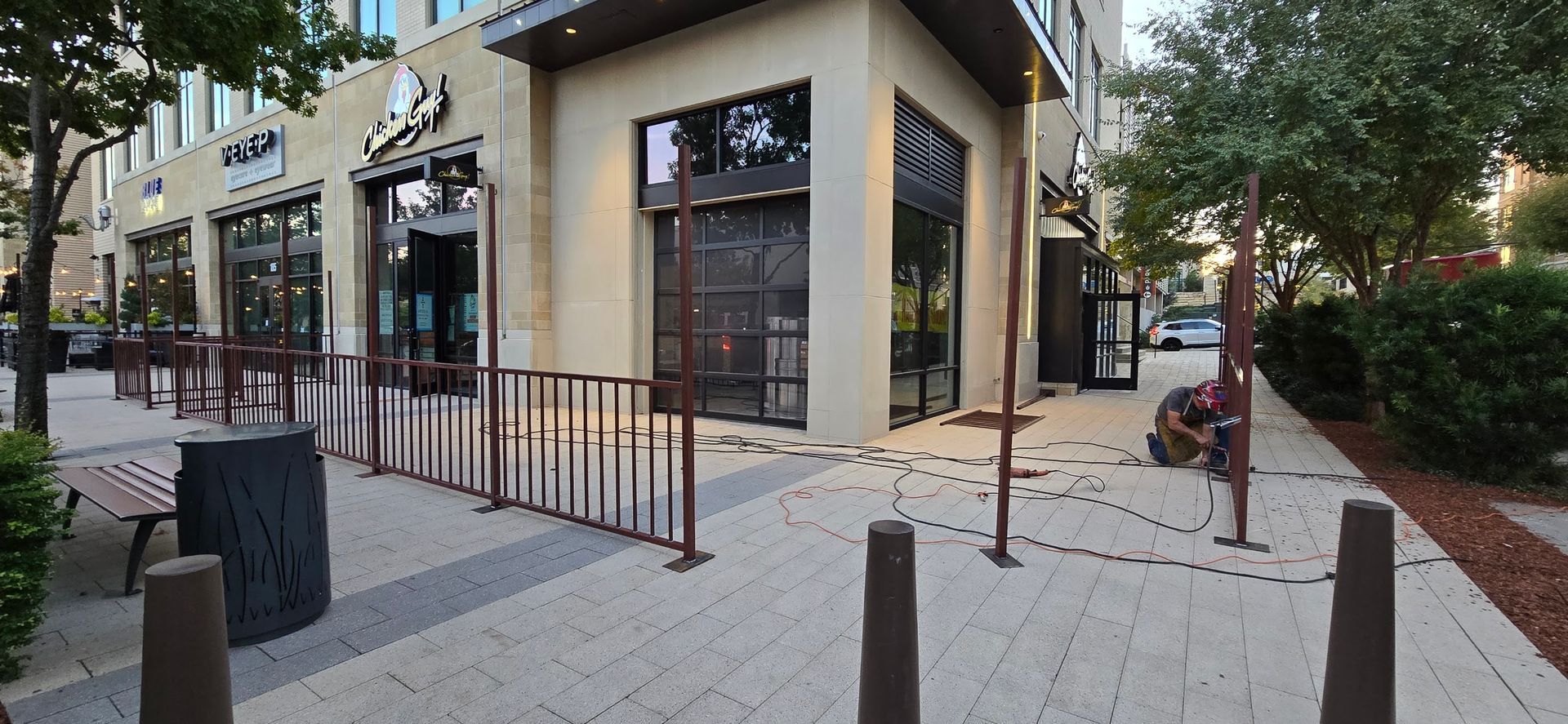 A building with a fence around it and a sidewalk in front of it.