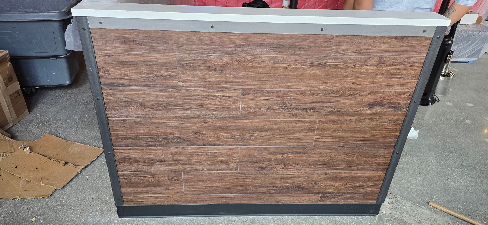 A wooden counter with a metal frame is sitting on the floor in a room.