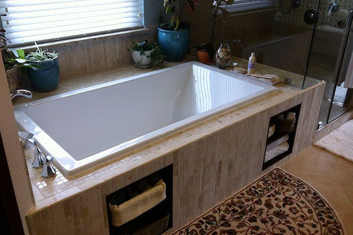 A bathtub is sitting in a bathroom next to a window.