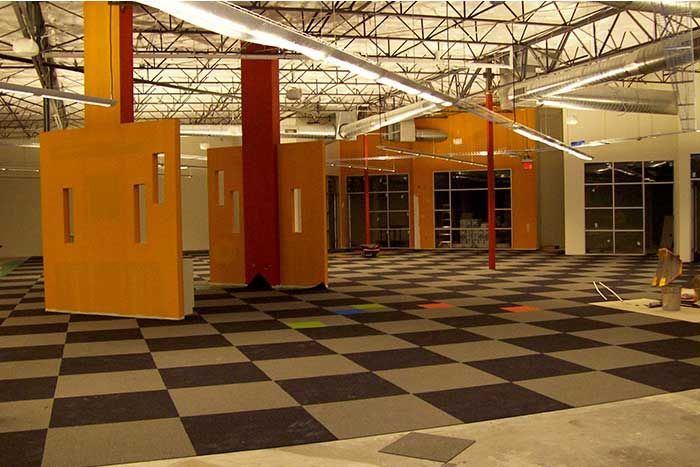 An empty room with a checkered floor and orange pillars