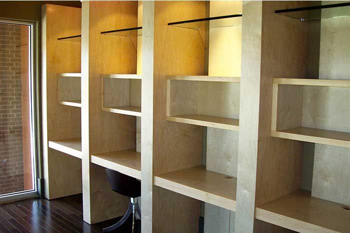 A room with a lot of shelves and a chair