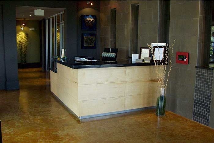A hotel lobby with a wooden counter and a clock on the wall