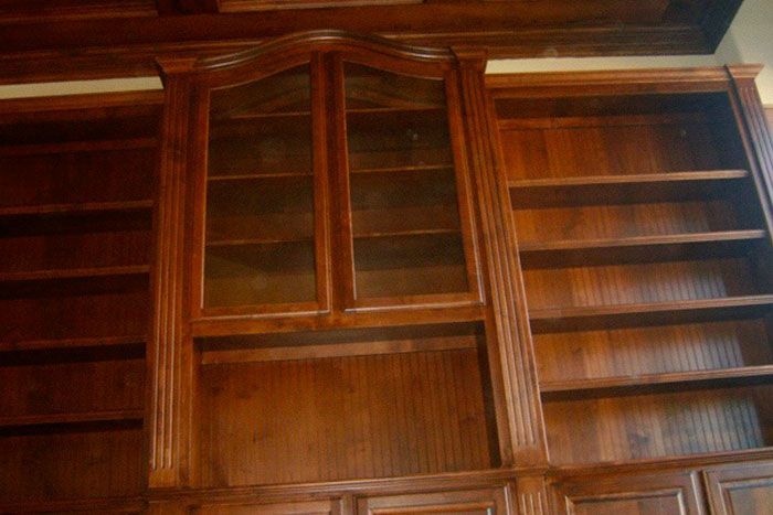 A large wooden bookshelf with glass doors and shelves