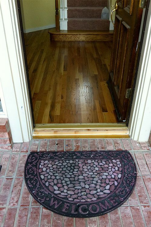 A welcome mat is sitting in front of a wooden door.