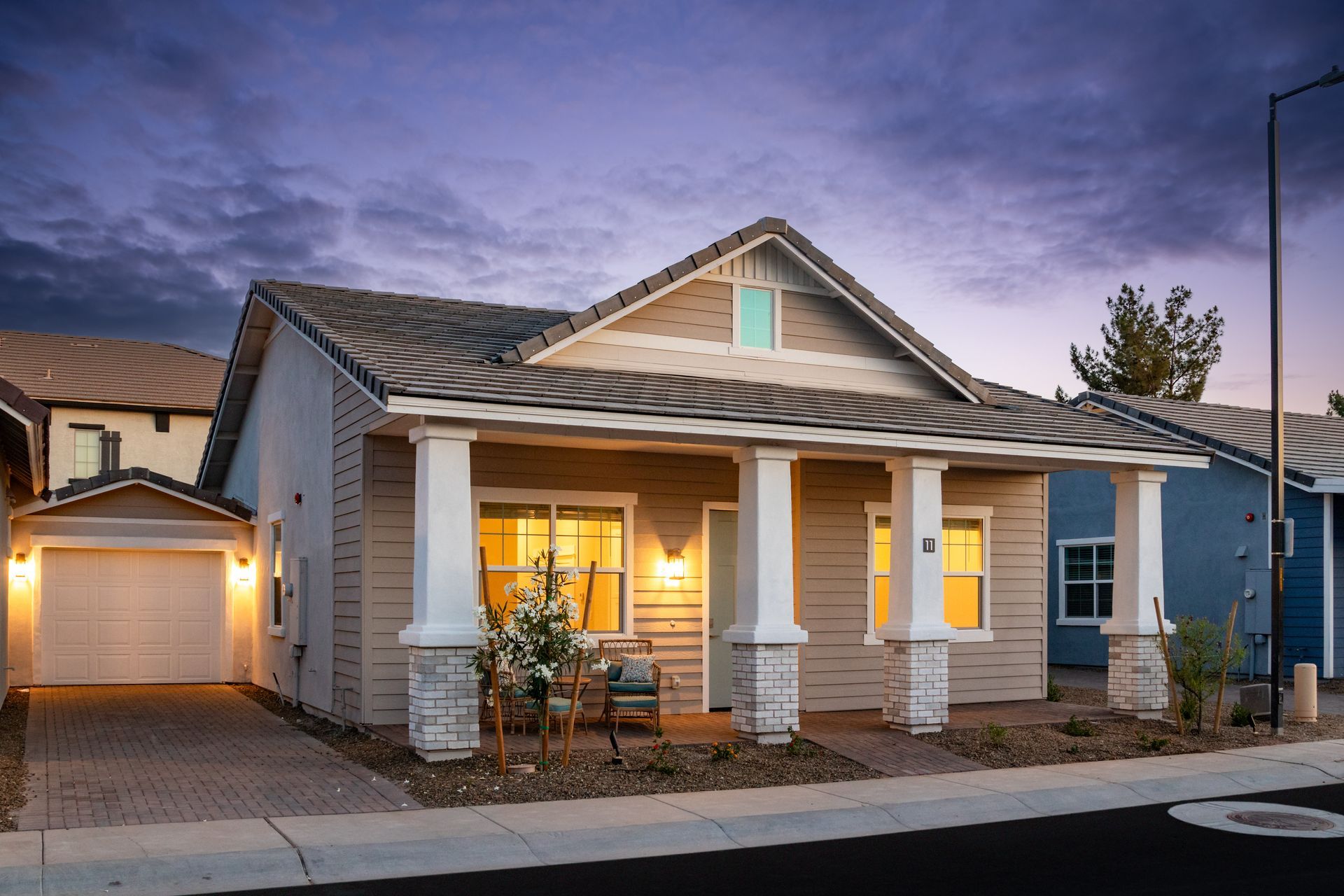 A house with a porch is lit up at night
