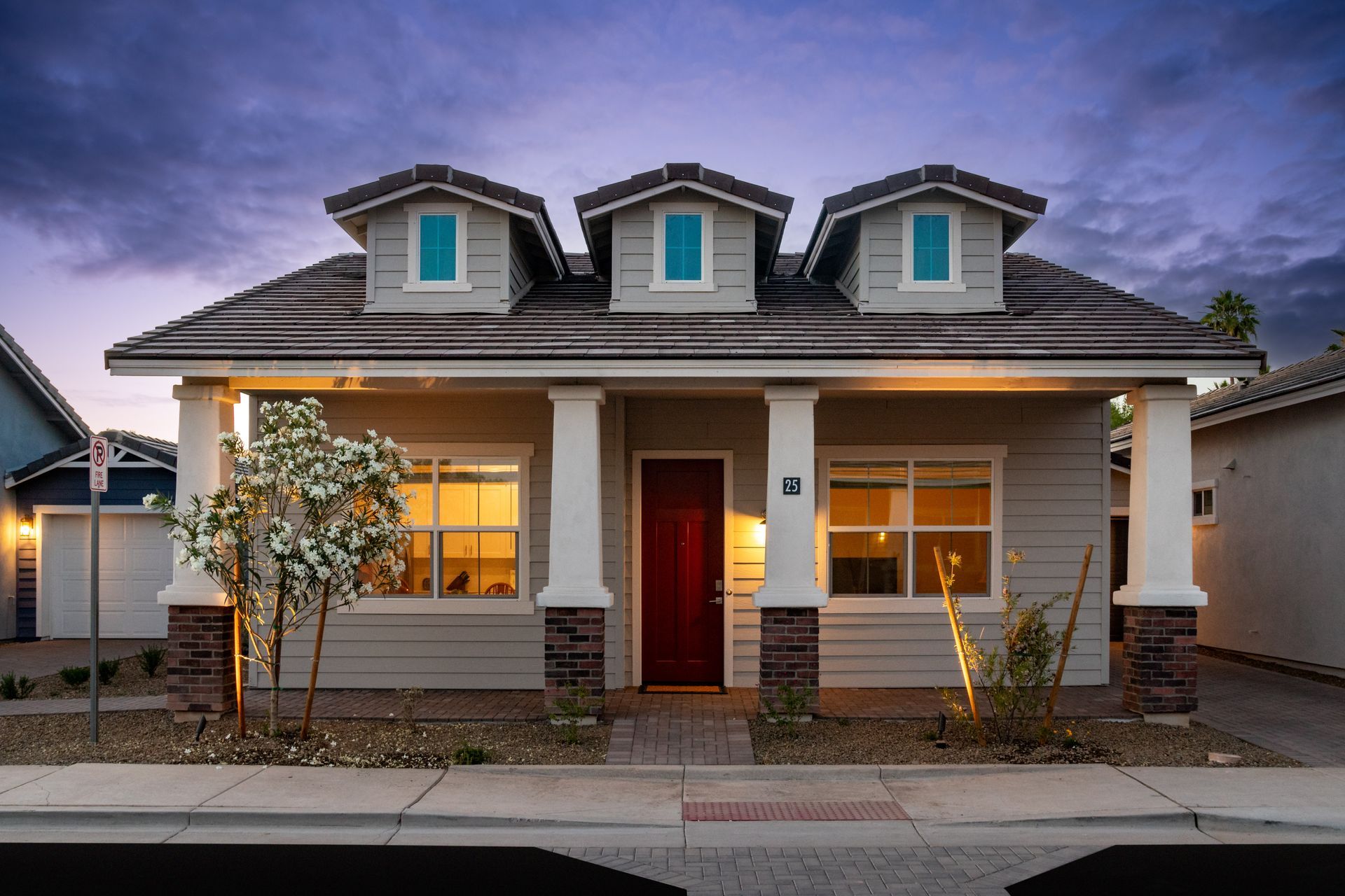 A house with three dormers and a red door