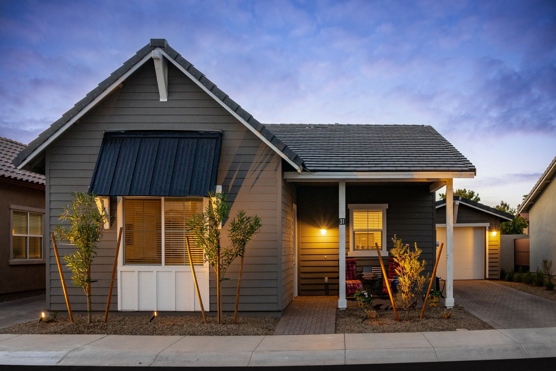 A small house with a porch and solar panels on the roof