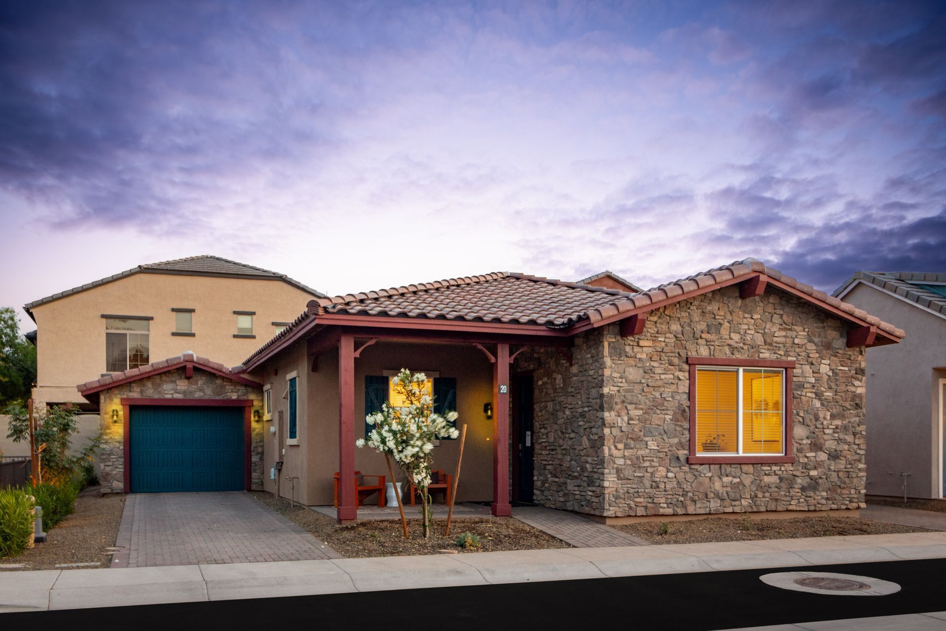 A house with a stone facade and a blue garage