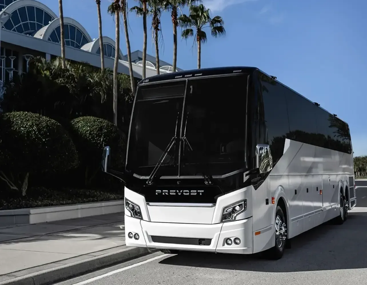 A large white and black bus is parked on the side of the road.