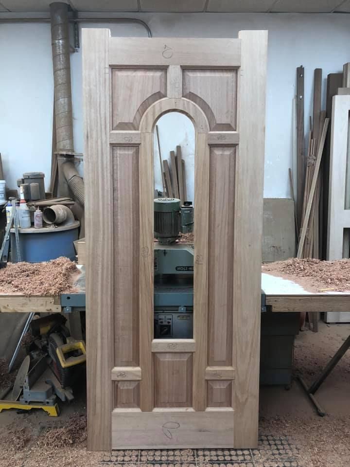 A wooden door is being built in a workshop