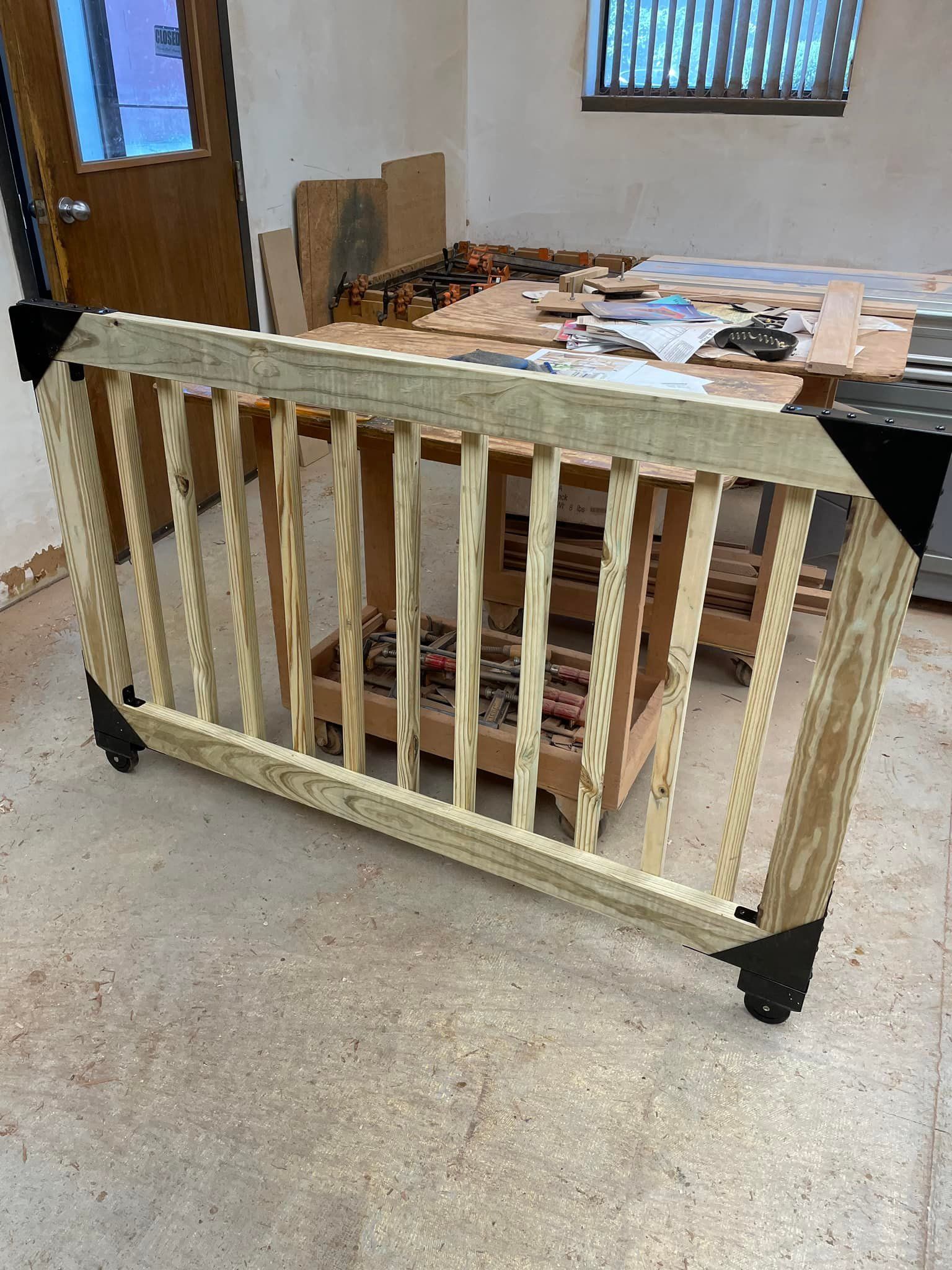 A wooden railing is sitting on the floor in a room.