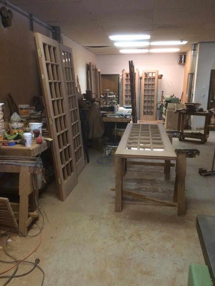 A woodworking shop with lots of wooden doors and a table.