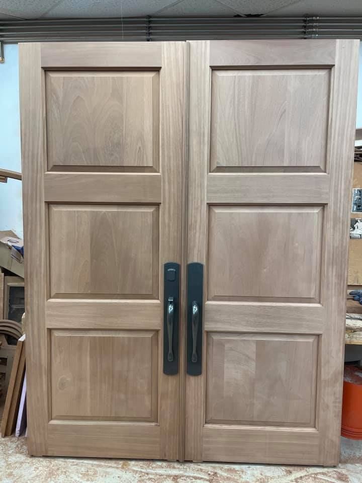 The front door of a house with two wreaths on it.