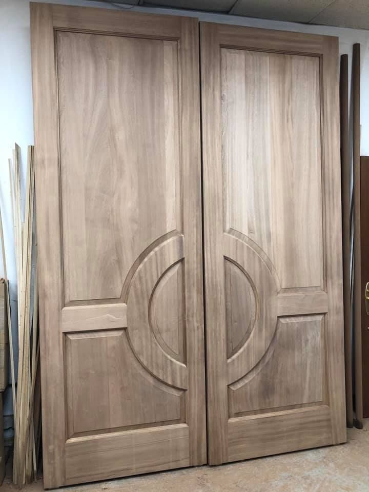 A pair of wooden doors are sitting on top of each other in a room.