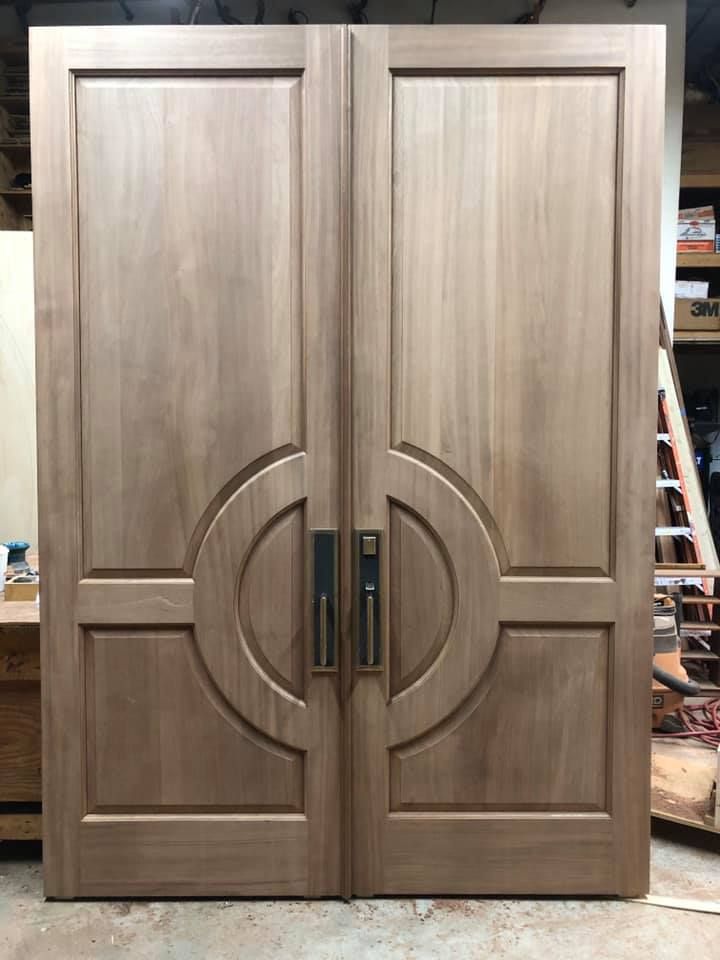 A pair of wooden doors sitting on top of a wooden table.