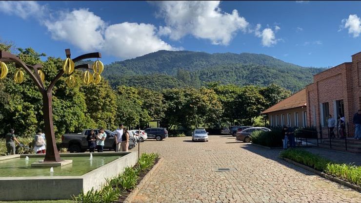 Vista da fábrica de chocolate em Pomerode, com cenário de montanha ao fundo.