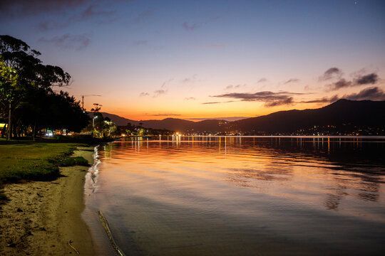 Vista do mar ao entardecer com montanhas ao fundo