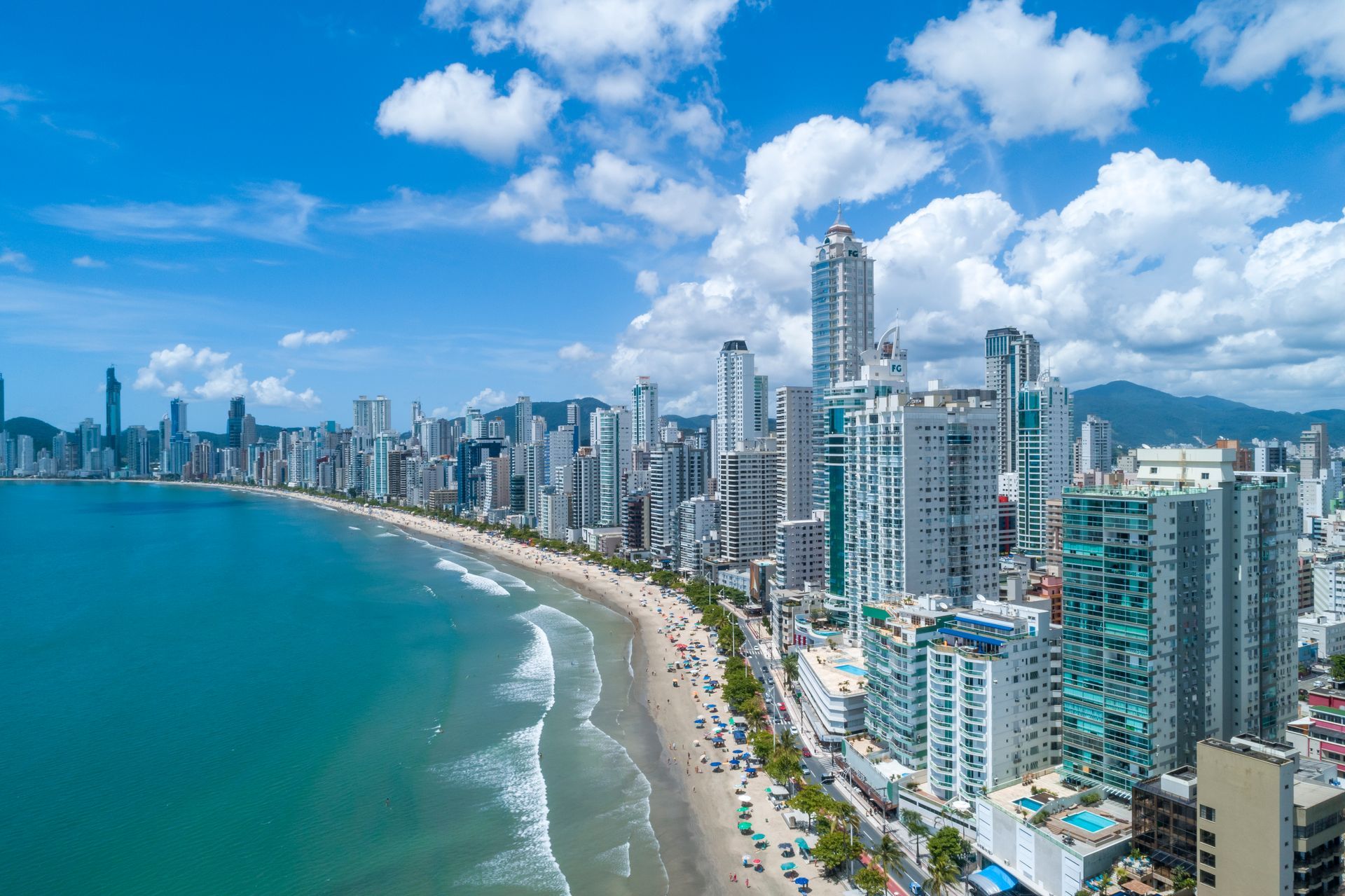 Vista aérea da orla de Balneário Camboriú em um dia ensolarado.