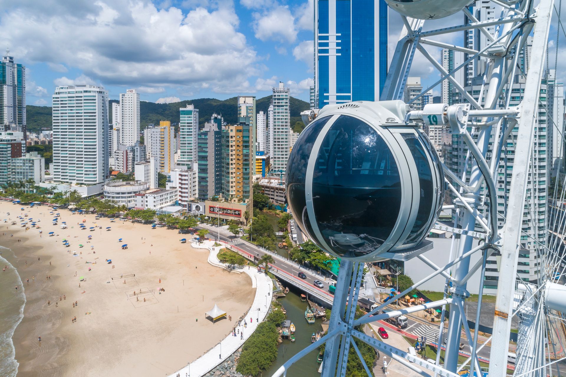 Cabine da roda gigante de Balneário Camboriú com vista da praia e dos prédios.