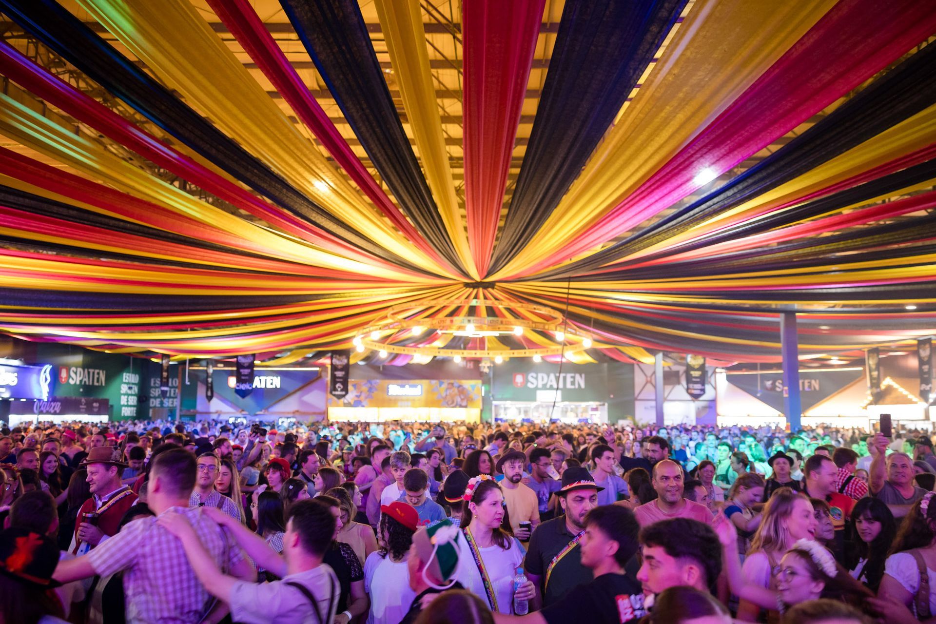 Público celebra em pavilhão decorado com fitas da Oktoberfest
