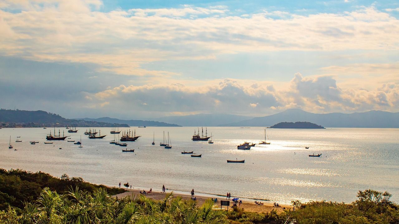 Barcos ancorados em praia com vista para ilhas