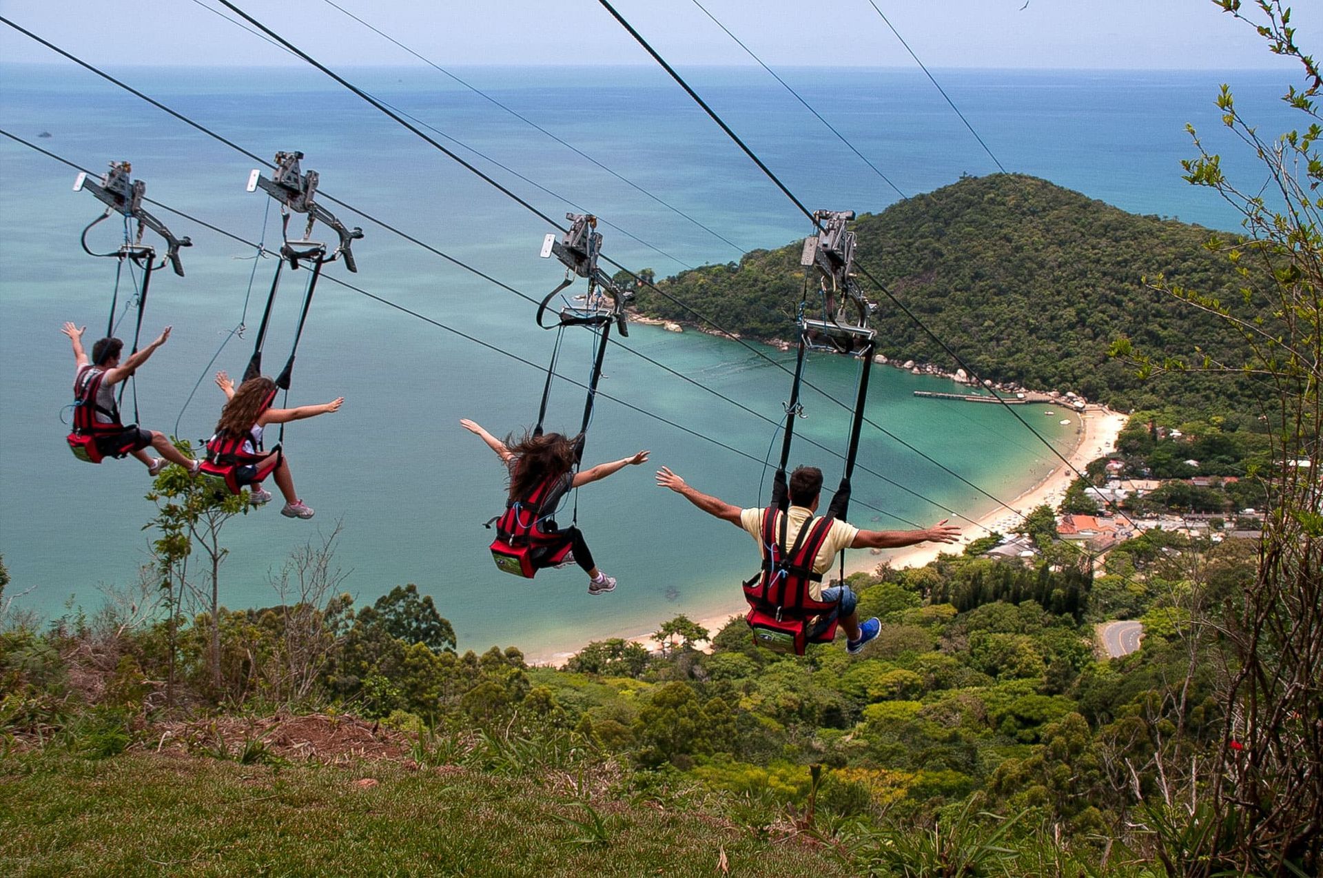 Pessoas descendo na tirolesa do Parque Unipraias
