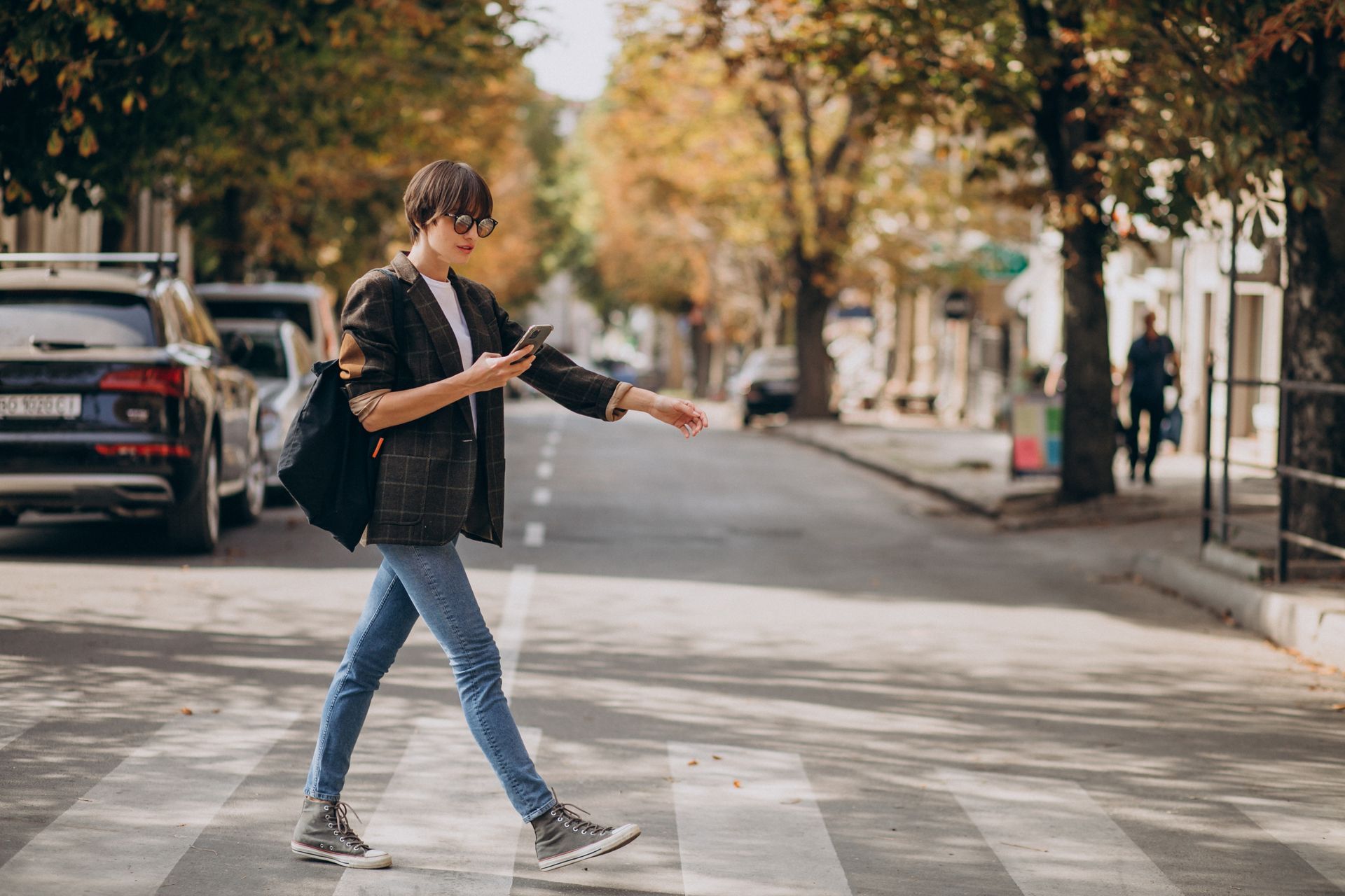 Turista caminhando por centro urbano, mexendo no celular
