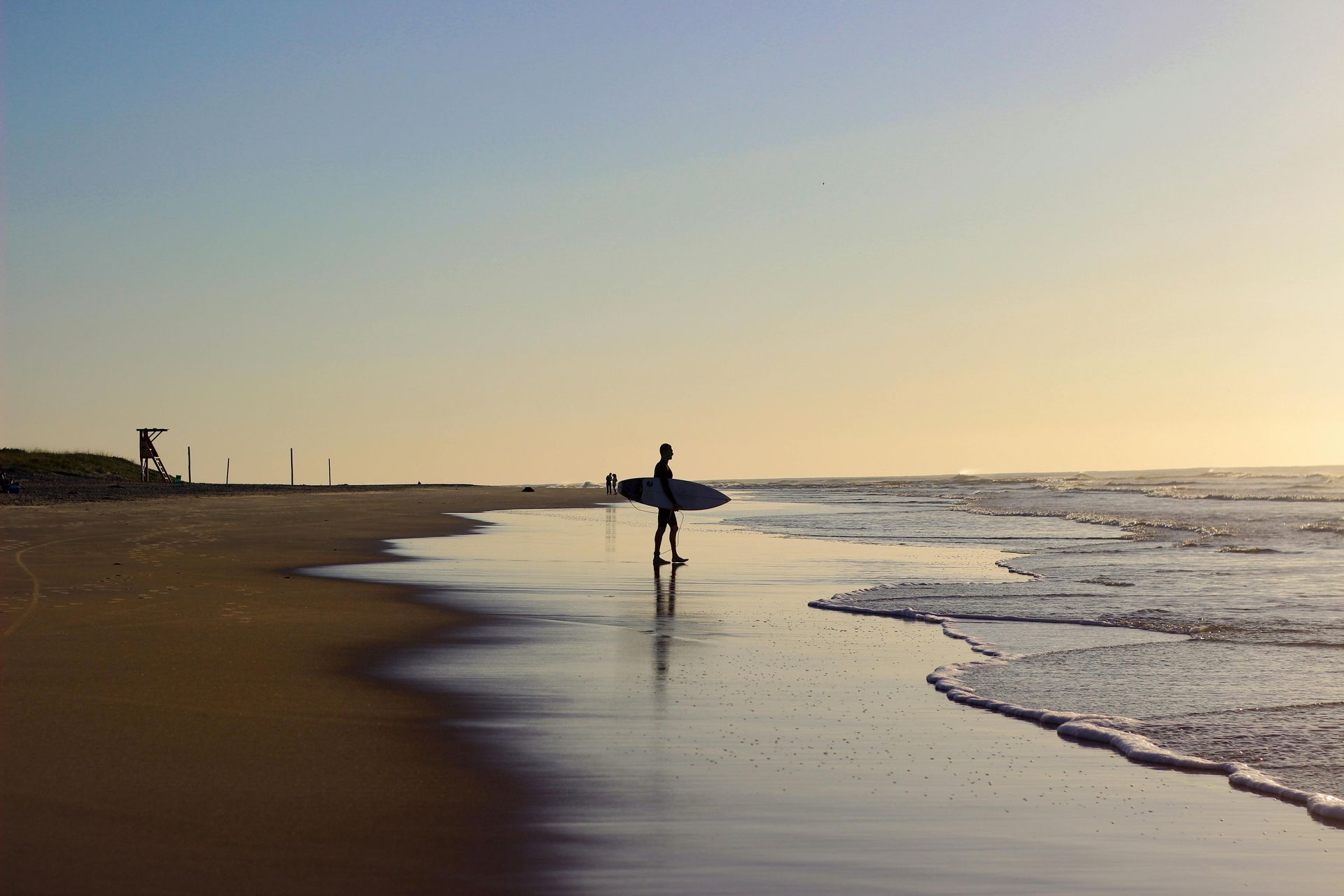 Surfista à beira-mar ao entardecer.