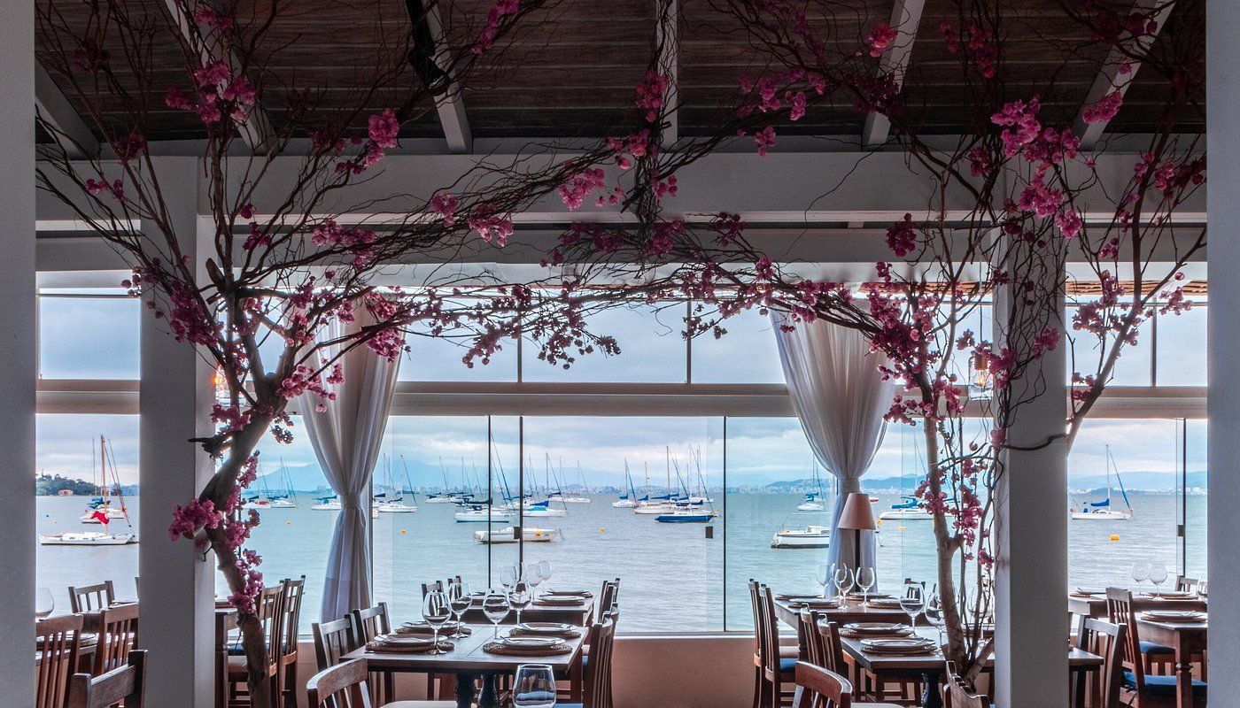 Restaurante com vista para o mar e barcos ancorados.