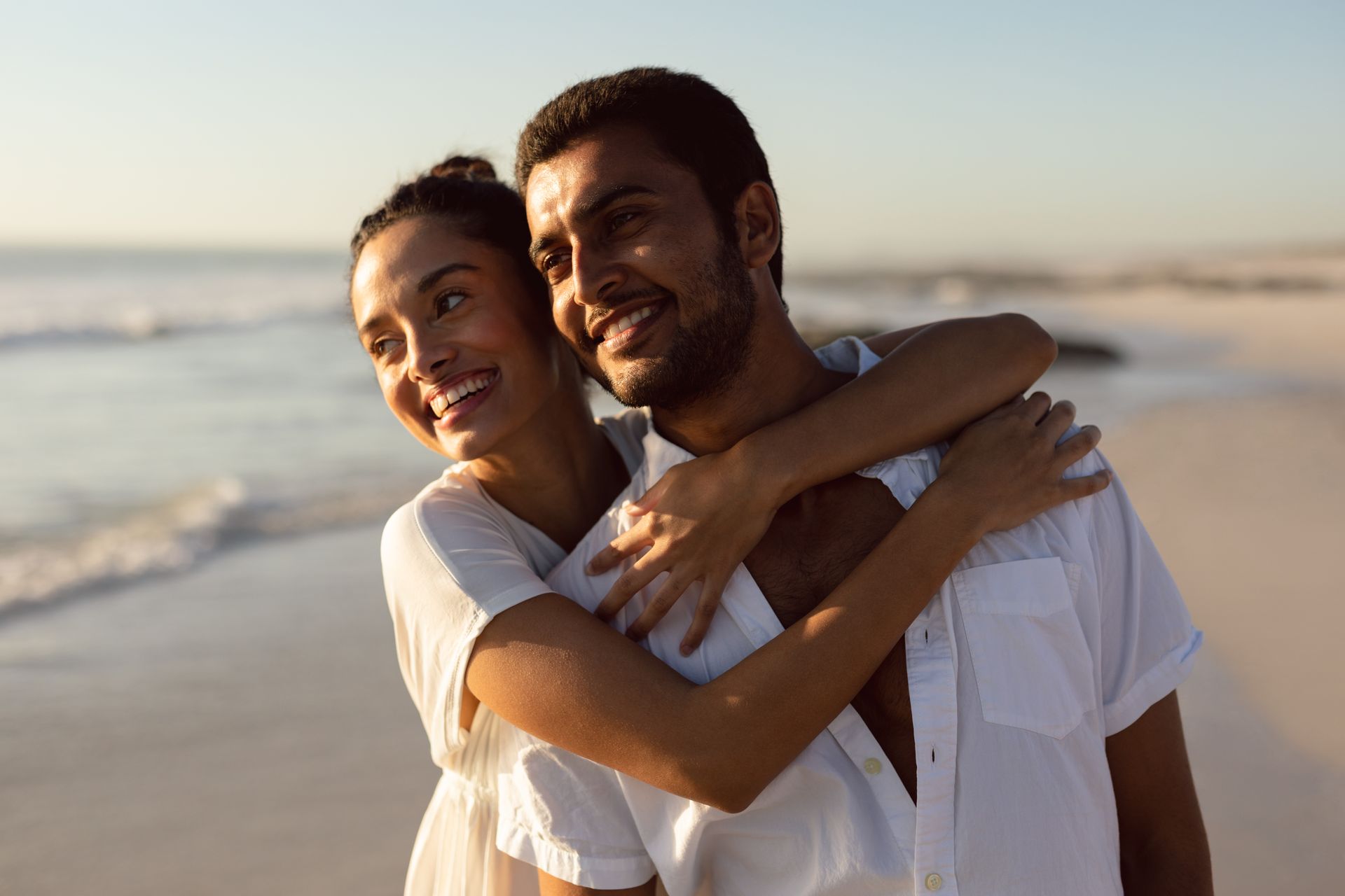 Casal abraçado na praia com vista para o mar em balneário camboriú