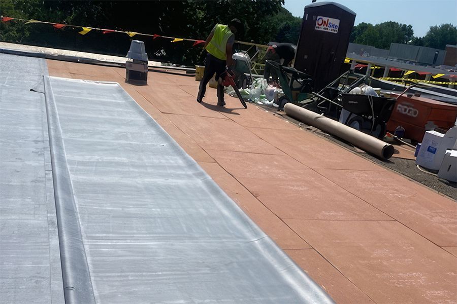 Image on top of Edina High School, with our crew preparing to complete an EPDM Roof System.