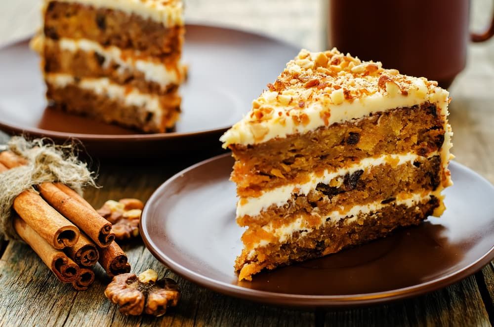 A Slice of Carrot Cake Is on A Plate Next to Cinnamon Sticks — Brews & Bites Beachside Cafe in Meikleville Hill, QLD