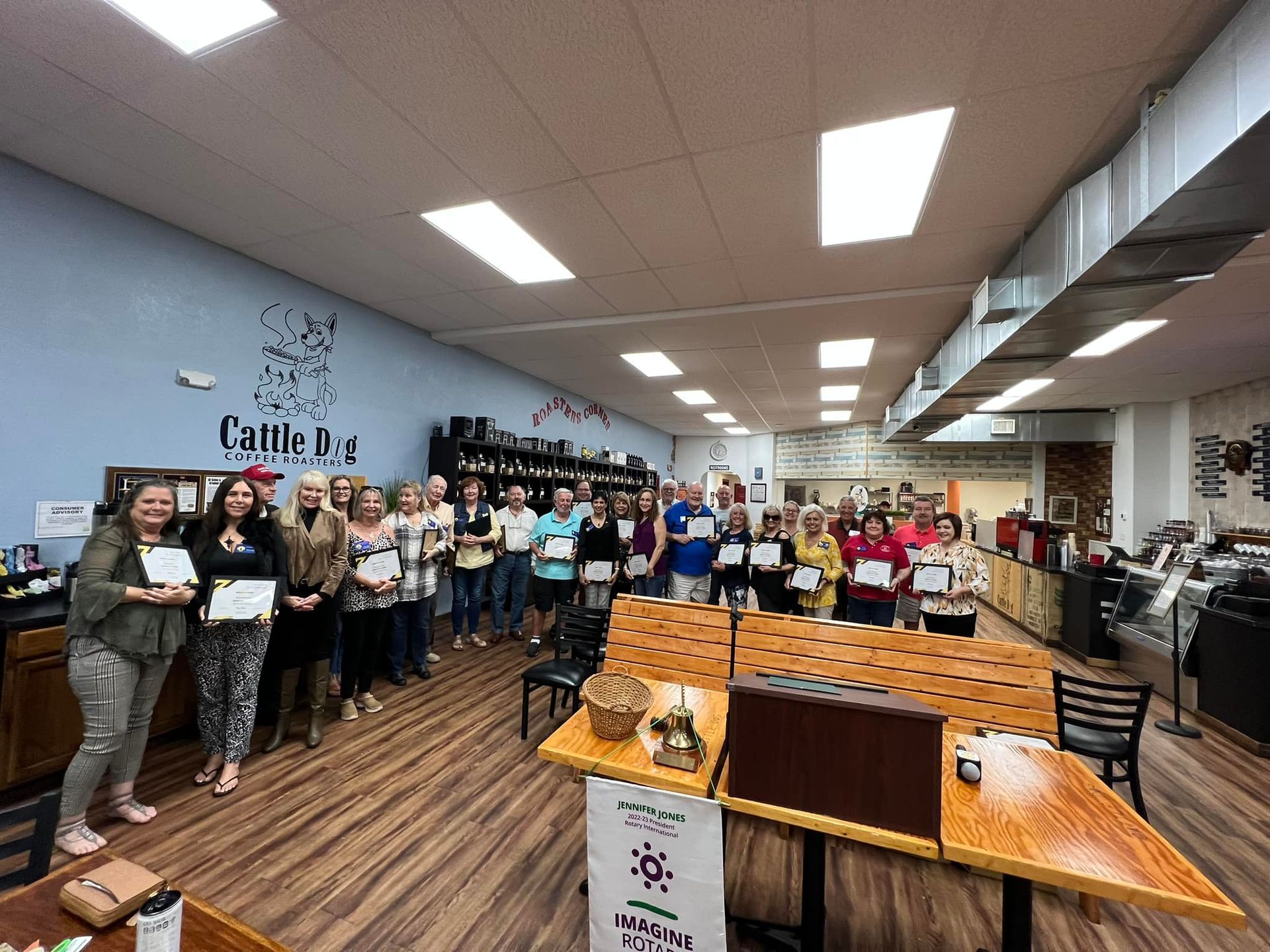 A group of people are standing in a room holding certificates.